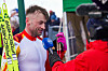 Petter Northug i hvit og oransje skiftemedalje blir intervjuet med mikrofoner etter NM på Lygna.