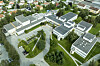 Aerial view of the NRK Tyholt complex in Trondheim, with several modern buildings and green surroundings.