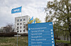 NRK-bygget på Marienlyst med NRK-flagg og blått informasjonsskilt i forgrunnen.