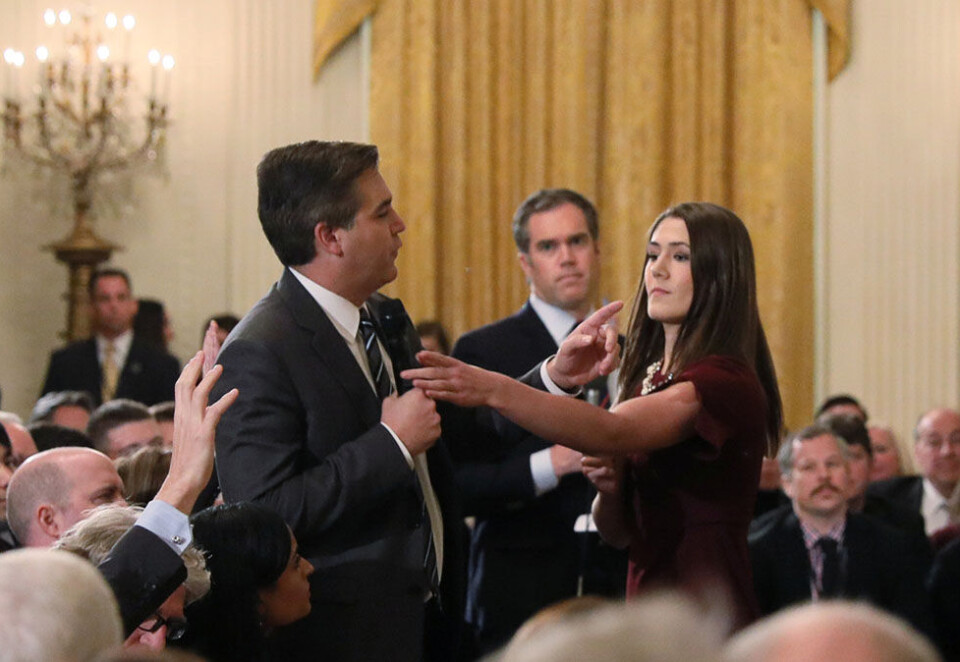 Amper stemning: Denne situasjonen blir av Det hvite hus framstilt som om CNN-reporter Jim Acosta går til håndgripeligheter mot en praktikant. Hun forsøker å ta mikrofonen, han holder fast på den. Foto: AP/NTB scanpix
