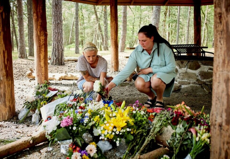Lite mediedekning i Norge: To tidligere klassekamerater av den avdøde legger blomster der den dansk-tanzanianske 28-åringen ble funnet drept i Bornholm i Danmark. Til New York Times sier danske aktivister at de mener at det danske politiet var for raske med å avfeie et mulig rasistisk motiv. Foto: NTB scanpix