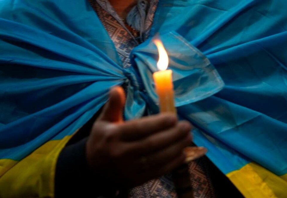 Fredsseremoni: En mann med det ukrainske flagget over skuldrene i en seremoni i Sao Jorge de Arroios-kirken i Lisboa i Portugal i mars i fjor. Foto: AP Photo/Armando Franca