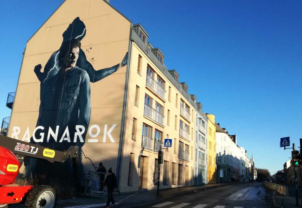 Den nye Netflix-reklamen for dramaserien «Ragnarok» kan vise seg å være ulovlig. - Vi tenkte det skulle settes opp en ramme, men vind gjorde det bedre å male direkte på veggen, sier Randi Helleberg som leder et av styrene til de to borettslagene bak veggen. Foto: Bjørn Lønnum Andreassen.