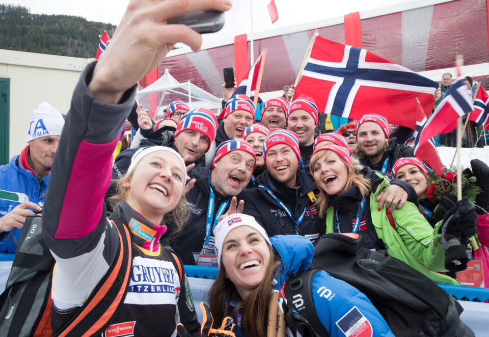 God glid i sponsormarkedet: Norske supportere hyller Ingvild Flugstad Østberg (t.v.) og Heidi Weng etter at de to langrennsjentene hadde gått opp monsterbakken i Val di Fiemme. Ski er også i vinden for norske sponsorer. Foto: Terje Pedersen / NTB scanpix