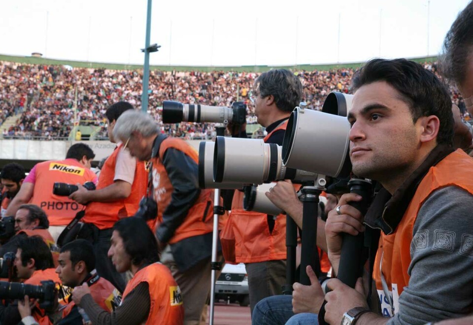 På jobb: Javad Parsa måtte selv flykte fra Iran og har siden reist både innenlands og utenlands for å dekke noen av verdens største og viktigste begivenheter. Her følger han VM-kvalifiseringskampen mellom Iran og Sør-Korea på Azadi stadion i Teheran.