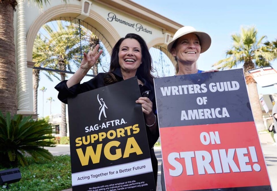 Leder Fran Drescher for skuespillerfagforeningen SAG (t.v.) og Meredith Stiehm, som leder manusforfatternes fagforening WGA, poserer sammen utenfor Paramounts studioer i Los Angeles. Manusforfatterne i Hollywood kommer tilbake på jobb onsdag, men skuespillerne er stadig i streik. Foto: Chris Pizzello / AP / NTB