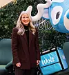 Nina Shovick står ved siden av Wolt-leveringsbag og blå Wolt-maskot utendørs